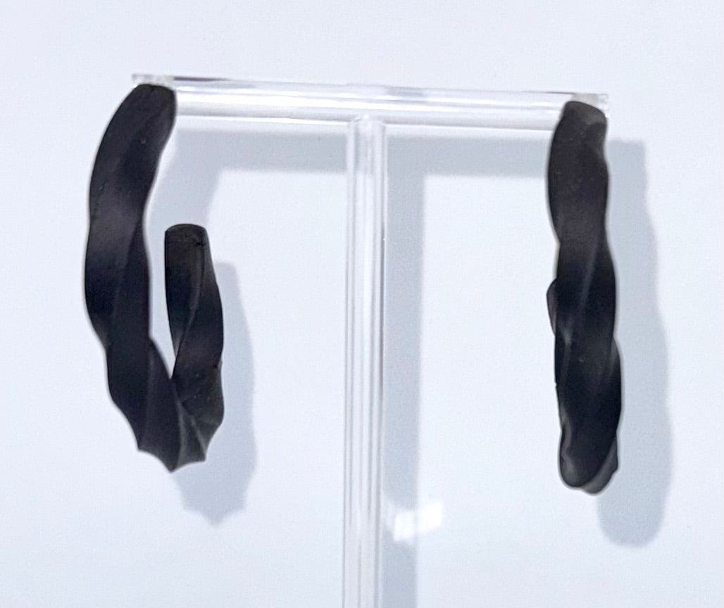 Black polymer clay twisted hoop earrings on a display stand – handmade bespoke earrings from an artisan jewellery store, part of a handcrafted clay jewellery collection perfect for gifting or everyday wearable art.