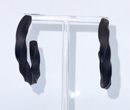 Black polymer clay twisted hoop earrings on a display stand – handmade bespoke earrings from an artisan jewellery store, part of a handcrafted clay jewellery collection perfect for gifting or everyday wearable art.